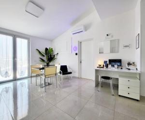 a white living room with a table and chairs at D ANNUNZIO house in Martinsicuro