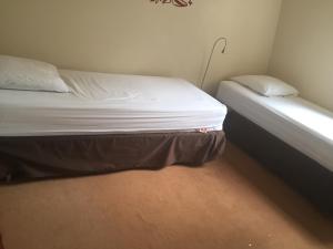 a small bedroom with a bed with white sheets and pillows at 52 Clichy Bed & Breakfast - Chambre d'hôtes in Paris