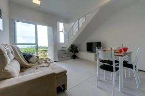 een woonkamer met een bank en een tafel met een televisie bij Beach Townhouses #C8 - Aconchego por Carpediem in Aquiraz