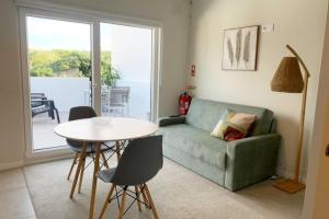 a living room with a couch and a table at Cantinho do Pópulo - Beach House in Ponta Delgada