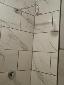 プレトリアにあるComfort place 2の白い大理石の壁のバスルーム(シャワー付)