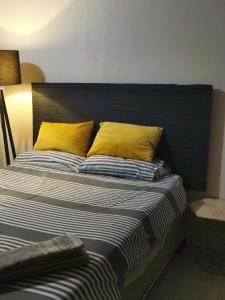 a bed with two yellow pillows on top of it at Comfort place 2 in Pretoria