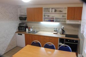 a kitchen with wooden cabinets and a sink and a table at Chata Větrník u Černého dolu v Krkonoších in Lauterwasser