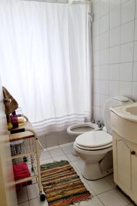 y baño con aseo y cortina de ducha. en Almagro 3 ambientes/Cochera en Buenos Aires