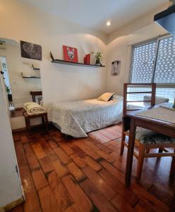 1 dormitorio con 1 cama y suelo de madera en Almagro 3 ambientes/Cochera en Buenos Aires