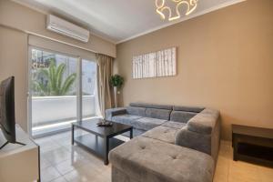 a living room with a couch and a tv at Rhodes Island Elli Beach Apartments in Rhodes Town