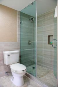 a bathroom with a toilet and a glass shower at Crowne Plaza Executive Center Baton Rouge, an IHG Hotel in Baton Rouge