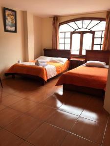 una camera con due letti e una finestra di Hostal Viajero's a Baños