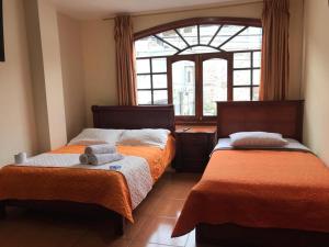 sypialnia z 2 łóżkami i oknem w obiekcie Hostal Viajero's w Baños