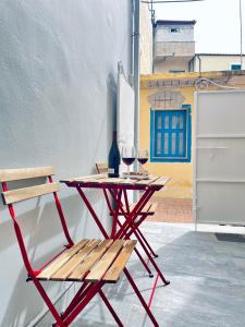 a red table with a chair and wine glasses at Number 6 in Zakynthos Town