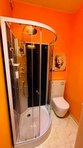 La salle de bains orange est pourvue d'une douche et de toilettes. dans l'établissement smart&beautiful HOSTEL, à Nordkirchen