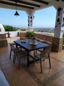 una mesa y sillas en un patio con vistas en Casa rural La Matriche, en Mijas