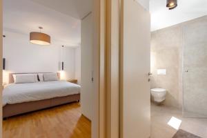 een slaapkamer met een bed en een badkamer met een douche bij Olea in Ika