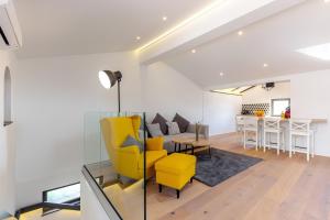 een woonkamer met een gele stoel en een tafel bij Olea in Ika