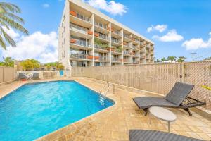 a swimming pool with a chair and a building at Island Surf 601A in Kihei