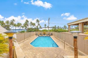a swimming pool in a backyard with a fence at Island Surf 601A in Kihei