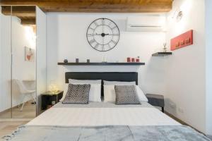 una camera da letto con un grande letto con un orologio sul muro di Antico Loft Como a Como