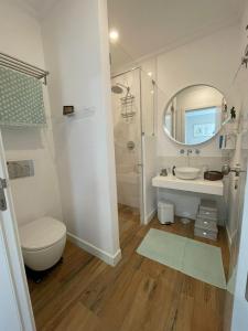 ein Badezimmer mit einem WC, einem Waschbecken und einem Spiegel in der Unterkunft Casa de Cece in Lagoa