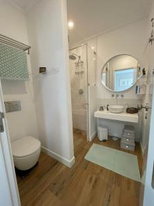 W łazience znajduje się toaleta, umywalka i lustro. w obiekcie Casa de Cece w mieście Lagoa