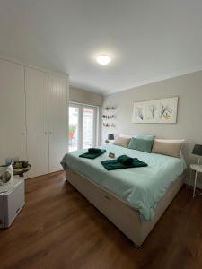 a bedroom with a large bed with green sheets at Casa de Cece in Lagoa