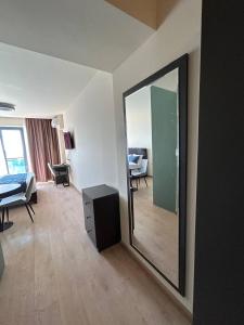 a living room with a mirror and a bedroom at Студия с потрясающим видом на море в Orbi Beach Tower in Batumi