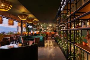 een restaurant met tafels, stoelen en planten bij Blues Suites Medellín in Medellín