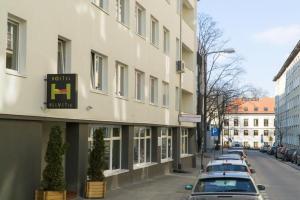 rząd samochodów zaparkowanych przed budynkiem w obiekcie Hostel Helvetia - PRIVATE ROOMS in CITY CENTER and OLD TOWN w Warszawie
