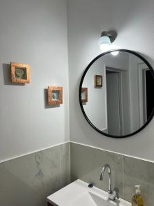 baño con espejo y lavabo en Villa General Belgrano Lago Los Molinos in 