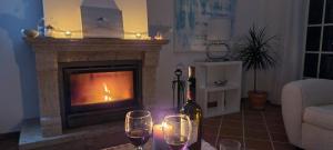 ein Wohnzimmer mit einem Kamin und 2 Gläsern Wein in der Unterkunft Penthouse Casa Astona in Amoreira