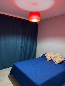 1 dormitorio con cama azul y luz roja en Villa General Belgrano Lago Los Molinos in 
