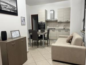 sala de estar y cocina con sofá y mesa en Casa Manthone - Intero Appartamento, en Pescara