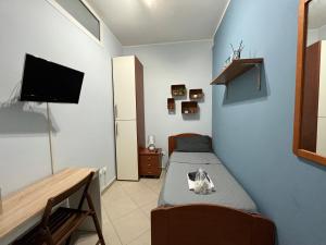 a small bedroom with a bed and a tv at casa Manthone - LuxRental Apartments in Pescara