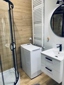 La salle de bains blanche est pourvue d'un lavabo et d'une douche. dans l'établissement Parkcity Centrum, à Katowice