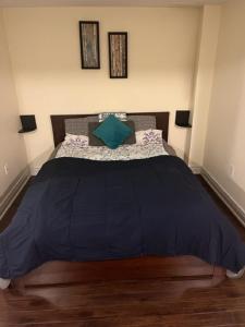 1 dormitorio con 1 cama grande y edredón azul en Cozy & Spacious Suite with Private Bathroom near Toronto Airport !, en Mississauga