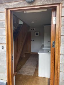 an open door to a room with a staircase at Hideaway Barn Coltishall in Coltishall