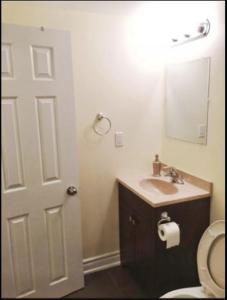 y baño con aseo, lavabo y espejo. en Cozy & Spacious Suite with Private Bathroom near Toronto Airport !, en Mississauga