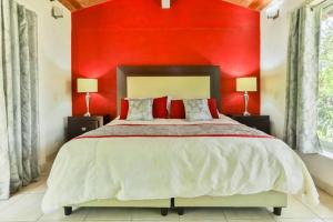 a red bedroom with a large bed with two lamps at Casa MALI con alberca. in Malinalco