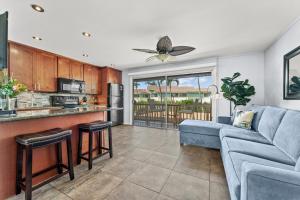 a living room with a blue couch and a kitchen at Wailana Sands 206 in Kihei