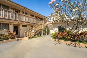 a building with stairs and a tree in front of it at Wailana Sands 206 in Kihei