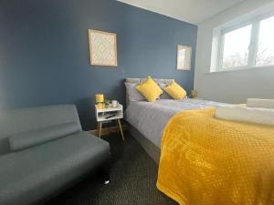 a blue bedroom with a bed and a chair at Stylish 2 bed apartment. in Birmingham