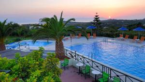 uma grande piscina com um pôr-do-sol ao fundo em My Cretan Village by Go4sea em Chorafakia