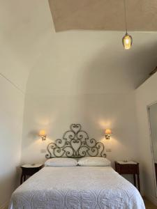 een slaapkamer met een wit bed met 2 kussens bij La Baia di Napoli in Capri