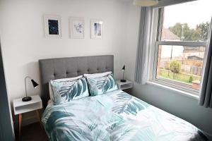 a bedroom with a bed with pillows and a window at The Coffee Pot Cottage in Town Centre FREE Parking in Stratford-upon-Avon
