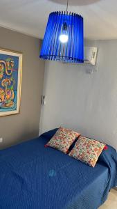 1 dormitorio con 1 cama azul y 1 lámpara azul en Villa General Belgrano Lago Los Molinos in 