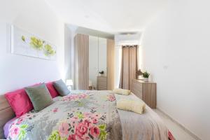 ein Schlafzimmer mit einem großen Bett mit einer Blumendecke in der Unterkunft H2 -Modern and Spacious 3 Bedroom Apartment in San Ġwann