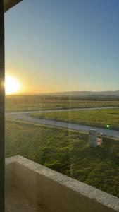 una ventana con vistas al campo y a la puesta de sol en Villa General Belgrano Lago Los Molinos in 