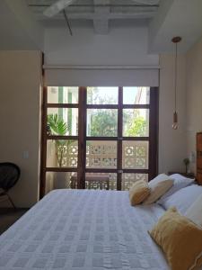 a bedroom with a large bed with a large window at La Casa del Totumo in Santa Marta