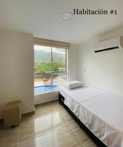 聖赫羅尼莫的住宿－Apartasol San Jeronimo Antioquia，一间卧室设有一张床和一个大窗户