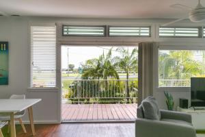 a living room with a sliding glass door to a patio at BEACHED @ YAMBA (water views, dog friendly, air con) in Yamba