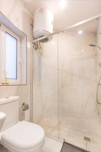 ein weißes Bad mit einer Dusche und einem WC in der Unterkunft H2 -Modern and Spacious 3 Bedroom Apartment in San Ġwann